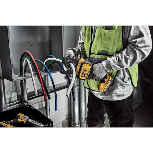 DEWALT Cable Cutter is used to cute cable to length by a tradesman in a electrical room.