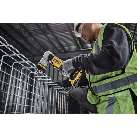 DEWALT Cable Tray Cutter is used by a kneeling tradesman to cut basket tray in a data center.