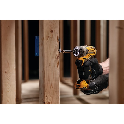 XTREME brushless cordless screwdriver fastening metal plate onto wooden beam.